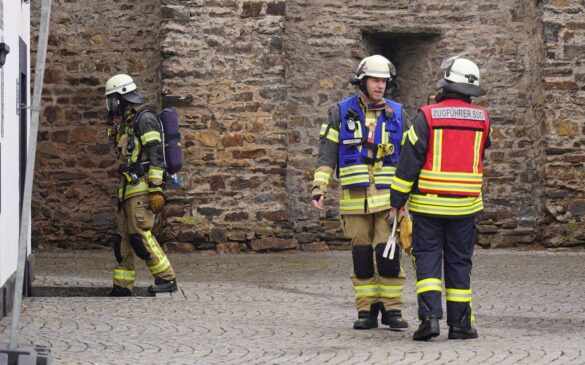 salhofplatz-6-min_56aktuell Feuerwehrleute in Schutzkleidung auf einem gepflasterten Platz.