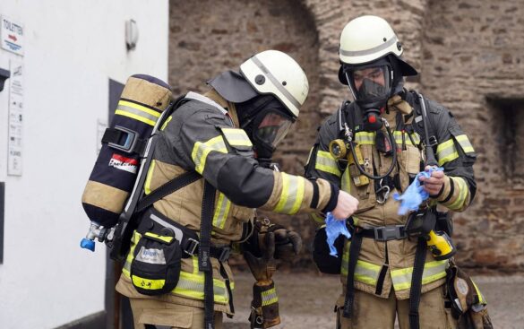 salhofplatz-7-min_56aktuell Zwei Feuerwehrleute in Schutzkleidung bei einer Einsatzbesprechung.