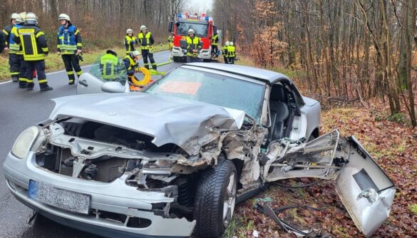 siershahn_vu_kran-5-min_56aktuell Verkehrsunfall mit beschädigtem Auto und Einsatzkräften auf der Straße.